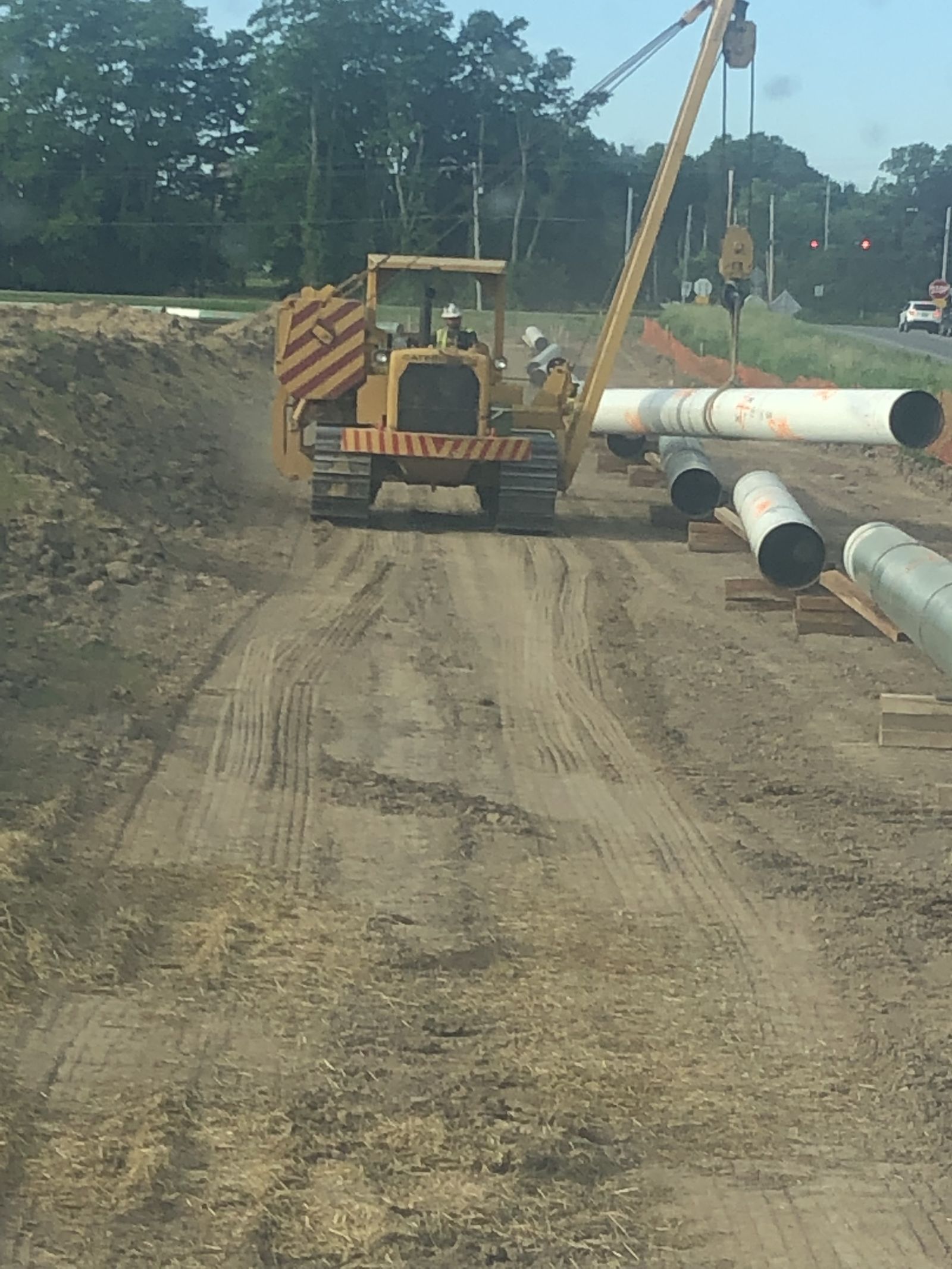 CAT pipelayer lifting pipe on job site